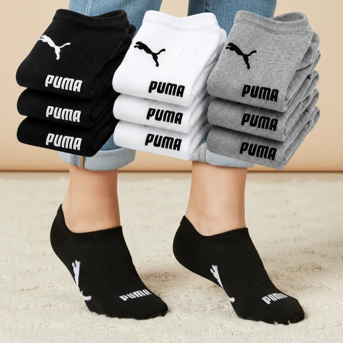 Kit com 9 pares de meias Puma nas cores preta, branca e cinza, exibindo o logo da marca, com um par sendo usado por uma pessoa vestindo jeans.