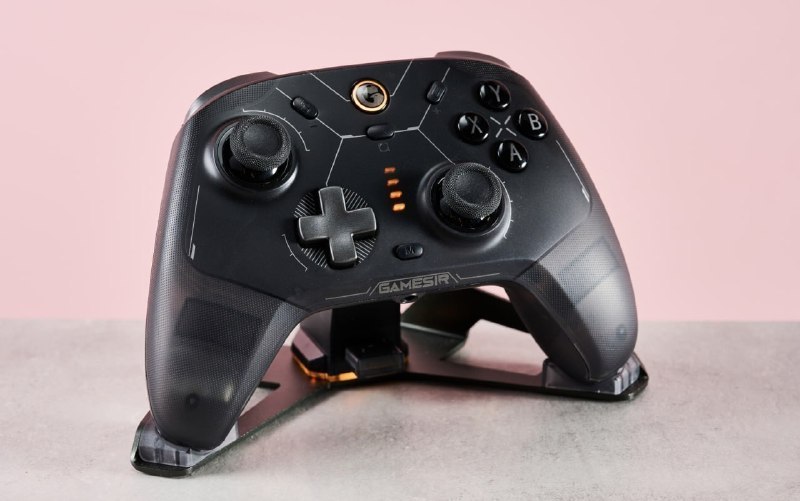 Controle sem fio GameSir Cyclone 2 na cor preta posicionado sobre sua base de carregamento, exibindo botões frontais, analógicos e indicadores de carga luminosos.