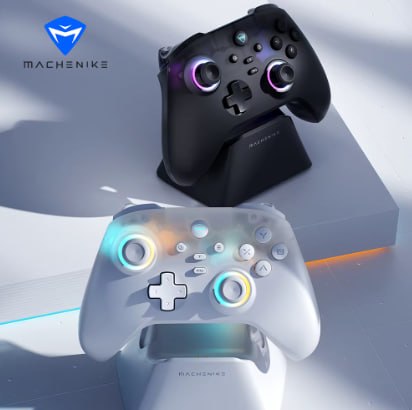 Dois controles sem fio Machenike G3 V2, um na cor preta e outro na cor branca, cada um posicionado em sua respectiva base de carregamento sobre uma superfície clara.