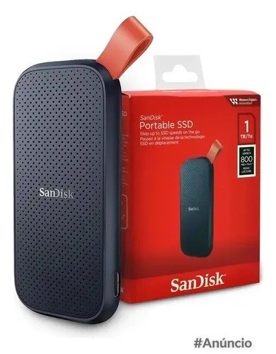 SSD externo portátil SanDisk de 1TB na cor preta com alça laranja, posicionado ao lado de sua embalagem original vermelha.
