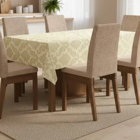 Toalha de mesa retangular em tecido Jacquard com estampa clássica, cobrindo uma mesa de madeira com seis cadeiras estofadas em ambiente de cozinha.