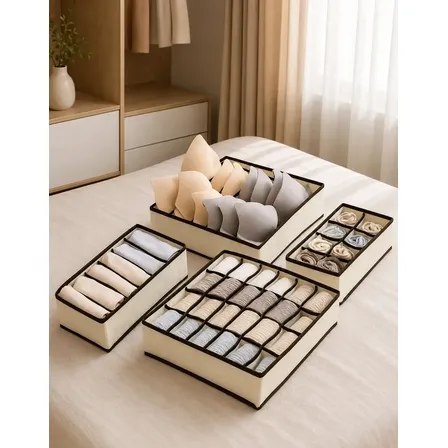 Kit com 4 colmeias organizadoras de gavetas em tecido bege com bordas marrons, contendo sutiãs, calcinhas e meias organizados em diferentes compartimentos sobre uma cama.